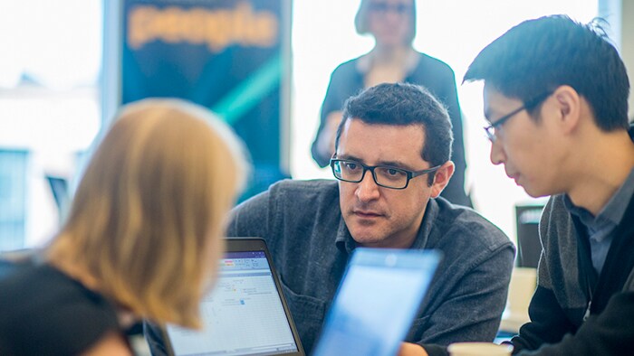 Three innovators with laptops have an intense discussion