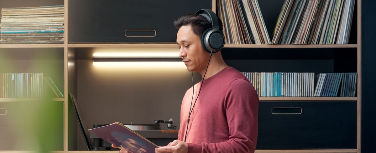 Un bărbat care ascultă muzică folosind căşti Philips X3