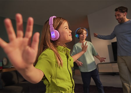 Copii care se bucură de muzică utilizând căştile auriculare Philips