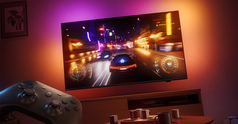 Un joc video de curse este afișat pe un televizor Philips Ambilight într-o cameră slab luminată.