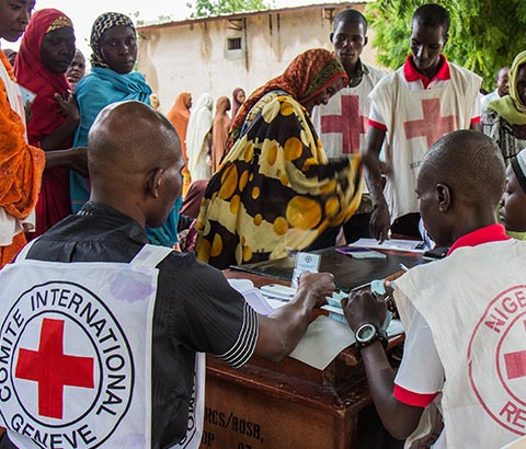 Personalul Crucii Roşii ajută oamenii afectaţi de criza alimentară