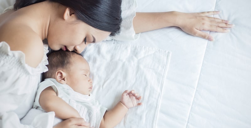 Mother sleeping with baby