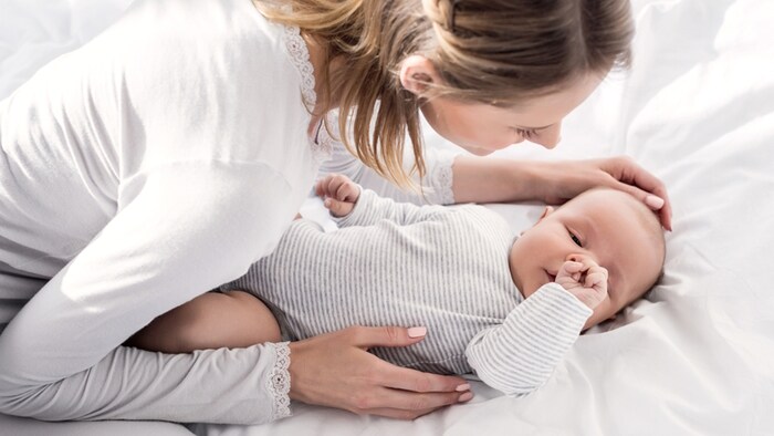 O mama isi pune copilul in pat in timp ce il alinta