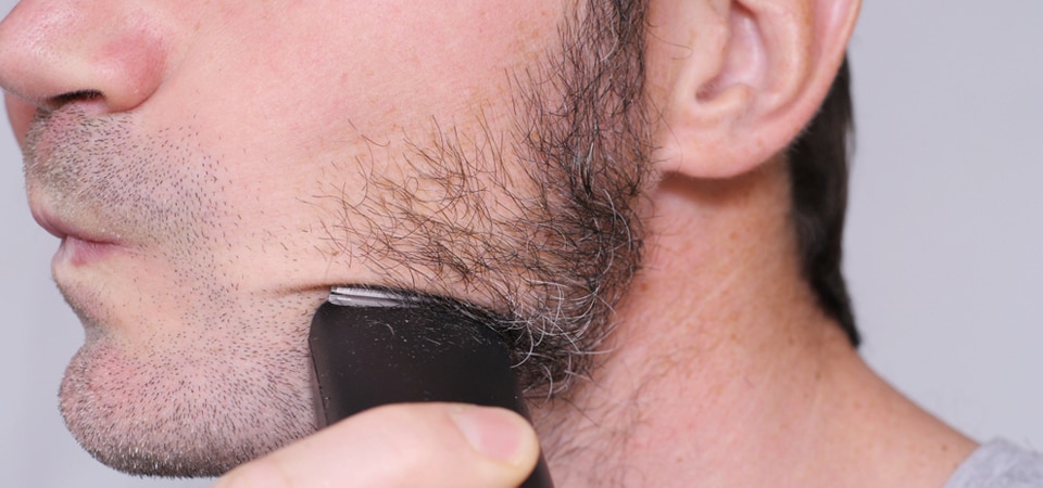 men shaving beard with trimmer