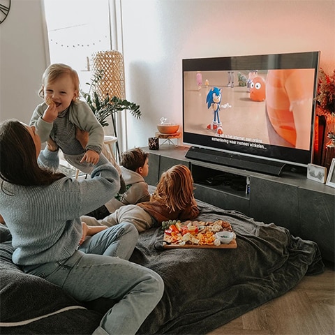 Familia se uită la televizor Ambilight